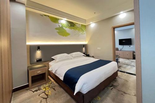 a bedroom with a large bed and a mirror at Ramada Linyi North in Linyi