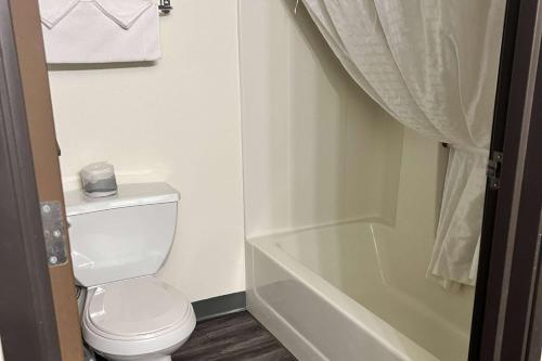 a bathroom with a toilet and a bath tub at Super 8 by Wyndham Nebraska City in Percival