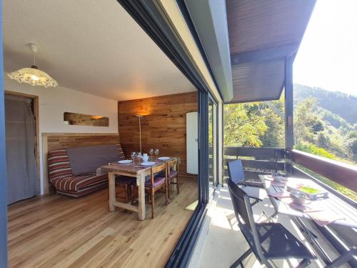 une chambre avec une table et un canapé sur un balcon dans l'établissement Sequoias - 102 - Appart moderne 4 pers, à Les Deux Alpes