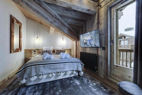 - une chambre avec un grand lit dans une pièce dotée de murs en bois dans l'établissement Résidence La Charpenterie - 4 Pièces pour 6 Personnes 344, à La Rosière