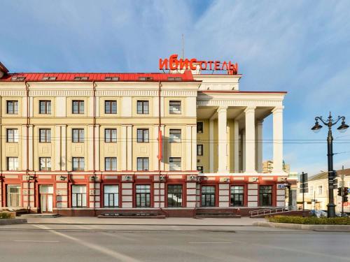 a building with a sign on the top of it at ibis Sibir Omsk Hotel in Omsk
