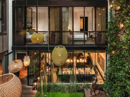 a building with a restaurant with tables and chairs at Balthazar Hotel & Spa Rennes - MGallery Collection in Rennes