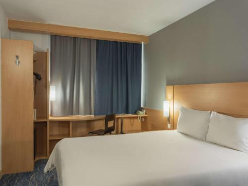 a hotel room with a large bed and a desk at Ibis Samara in Samara