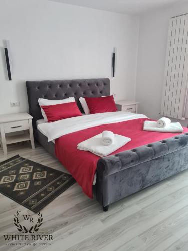 a bedroom with a large bed with red pillows at Pensiunea WhiteRiver Adults Only-Self check-in in Câmpulung Moldovenesc