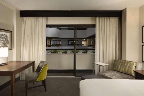 a living room with a desk and a living room with a table at Hyatt Regency Savannah in Savannah