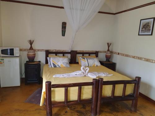 a bedroom with a bed with a bow on it at Thokozani Lodge in White River