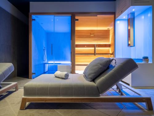 a couch sitting in a room with a room with blue lights at Hotel San Rocco in Muggia