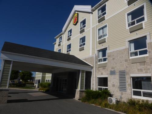 a building with a parking garage in front of it at Super 8 by Wyndham Peterborough in Peterborough