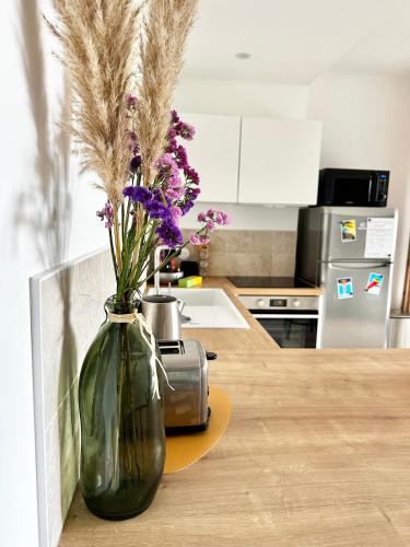 un vase avec des fleurs assis sur un comptoir dans une cuisine dans l'établissement Casamea - Studio, Parking, WiFi, Clim, Ajaccio, à Ajaccio