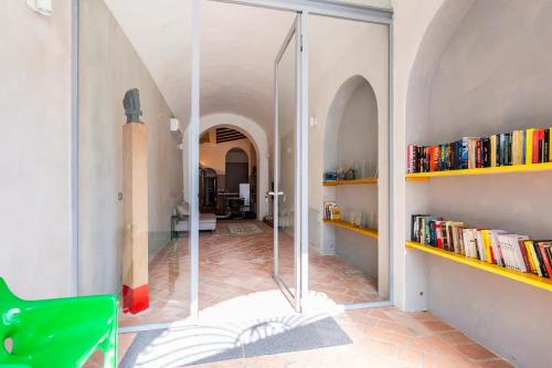 a glass door in a room with books at Loft 33 in Piacenza