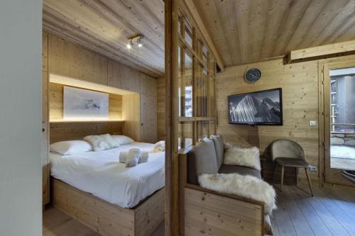 een slaapkamer met een bed en een tv aan de muur bij Residence Telemark - 2 Pièces pour 4 Personnes 104 in Val dʼIsère