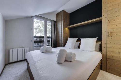 een slaapkamer met een groot wit bed met witte kussens bij Résidence RÉsidence Le Solaire - 3 Pièces pour 4 Personnes 484 in Val dʼIsère