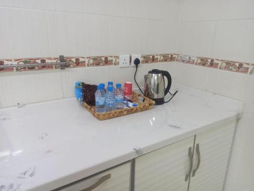 a counter with a basket of water bottles and a blender at سكن تله الظاهره in Al Madinah
