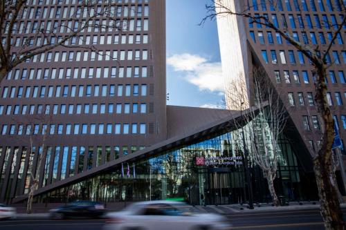 un edificio alto con un puente delante de él en Hilton Garden Inn Tbilisi Chavchavadze en Tiflis