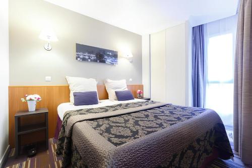 a hotel room with a bed and a window at Aparthotel Chez Adagio Paris La Défense-2P with Terrace in Courbevoie