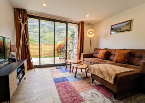 a living room with a couch and a table at Le Tucou - Gîte & Spa Tout confort in Campan