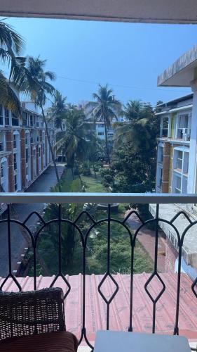a balcony with a view of a street and palm trees at Premium Luxury -1BHK at Candolim Beach with Free Wifi and Pool in Candolim