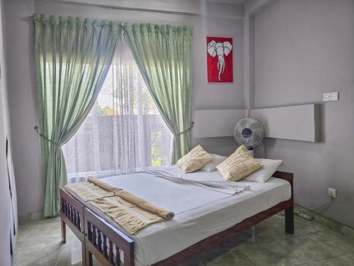 a bed in a room with a large window at The Brick House Kandy in Kandy