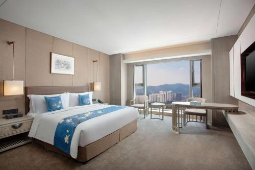 a hotel room with a bed and a large window at Kunming Huiyue Wyndham Hotel in Kunming