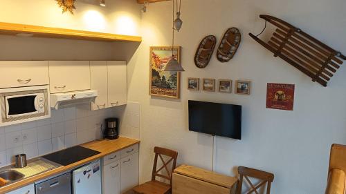 Il comprend une cuisine équipée d'une télévision murale. dans l'établissement Appt LA GRANGE 8 Luz St Sauveur - Centre Ville - T2 - 2-4 personnes - PARKING GRATUIT, à Luz-Saint-Sauveur
