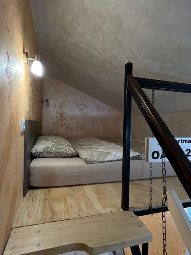uma pequena cama num quarto com uma escada em APARTMAN OAZA 24 em Surčin