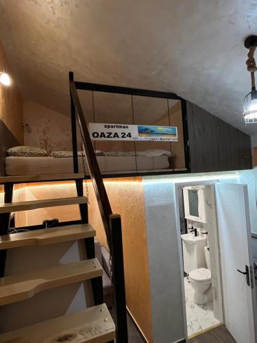 APARTMAN OAZA 24 في Surčin: غرفة مع سرير بطابقين ومرحاض