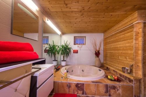 ein Bad mit einer großen Badewanne in einem Zimmer in der Unterkunft Designer-Chalets in Dienten am Hochkönig