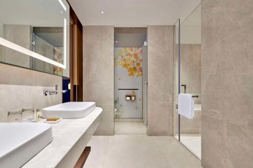 uma casa de banho com 2 lavatórios e um chuveiro em Hilton Garden Inn Suzhou Wuzhong em Suzhou