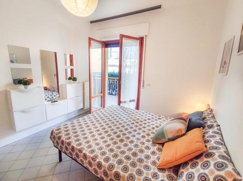una camera da letto con letto con cuscini e balcone di Trilocale Volta in seconda fila mare a San Benedetto del Tronto