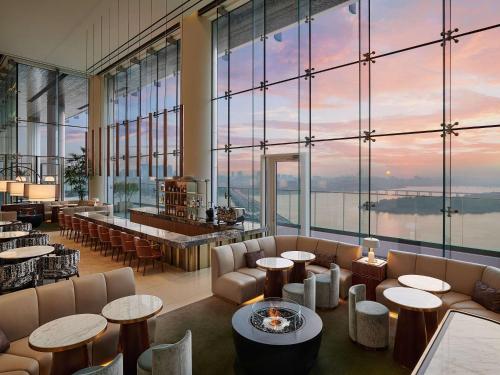 - un restaurant avec des tables, des chaises et de grandes fenêtres dans l'établissement Hotel Naru Seoul MGallery Ambassador, à Séoul