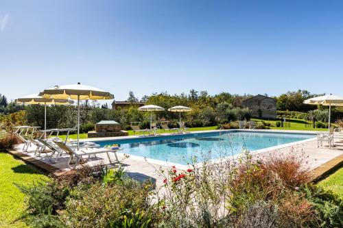 uma piscina com cadeiras e guarda-sóis num quintal em Gorgeous Villa Peccioli, with private pool, AC, Wifi em Legoli