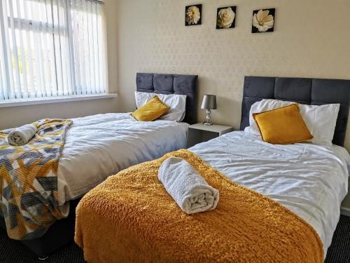 dos camas sentadas una al lado de la otra en un dormitorio en Stunning 3 Bedroom 5 beds House in Wolverhampton en Wolverhampton