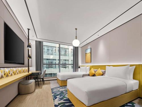 Habitación de hotel con cama y TV en Hilton Garden Inn Kunming Dianchi en Kunming