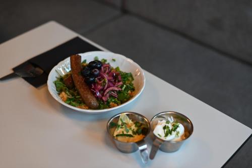 a bowl of salad and a plate of food on a table at Hotel Local 101 in Reykjavík
