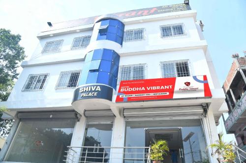 a building with a blue and red sign on it at Hotel Buddha Vibrant in Deoghar