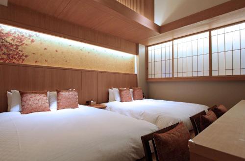 two beds in a room with two windows at KAYA Kyoto Nijo Castle, BW Signature Collection by Best Western in Kyoto
