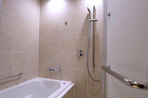 a bathroom with a shower with a tub and a sink at KAYA Kyoto Nijo Castle, BW Signature Collection by Best Western in Kyoto