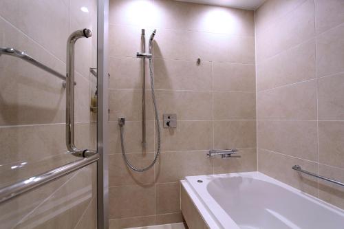 a bathroom with a shower and a bath tub at KAYA Kyoto Nijo Castle, BW Signature Collection by Best Western in Kyoto