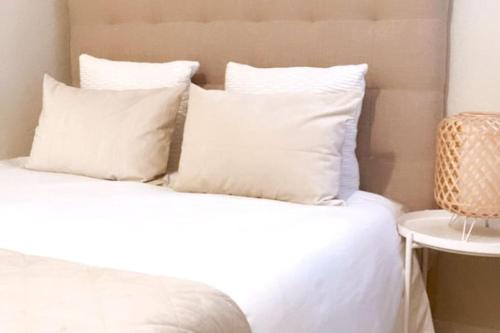 Una cama blanca con almohadas blancas encima. en BilboAppartment, en Bilbao