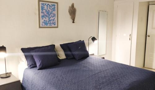 - une chambre avec un lit bleu et 2 oreillers bleus dans l'établissement 1br, 24hr security - City Charm with Poolside Peace, à Port-d'Espagne