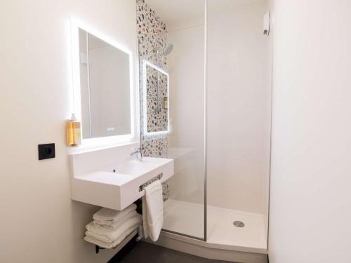 a bathroom with a sink and a shower at Greet Hotel Brest Aéroport in Guipavas