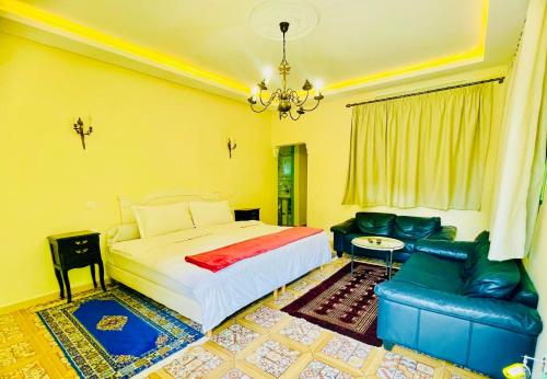 a bedroom with a bed and a couch and a chandelier at Villa Baddi Marrakech in Marrakesh