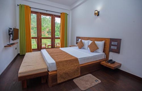 a bedroom with a bed and a large window at Wenasa Villa in Diyatalawa