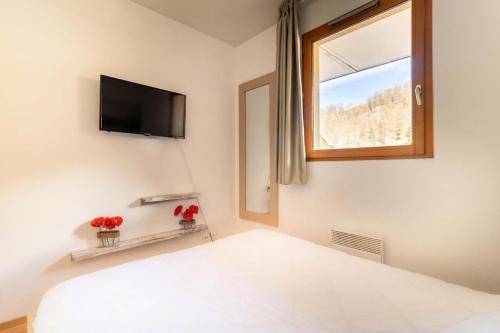 - une chambre avec un lit, une télévision et une fenêtre dans l'établissement Résidence Les Terrasses Du Soleil D'or - Appartement chaleureux avec terrasse vue pistes MAE-6864, aux Orres