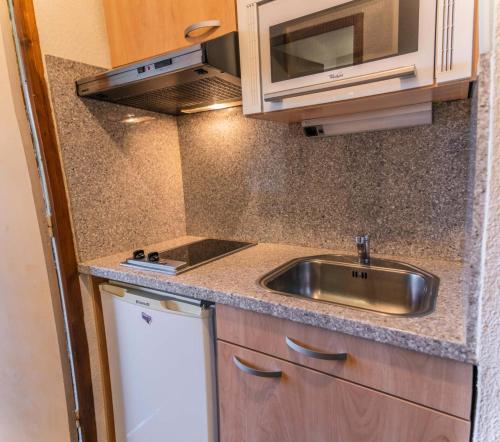 une petite cuisine avec un évier et un micro-ondes dans l'établissement Résidence Le Belvedere - Studio au coeur des Orres 1650 MAE-6944, aux Orres