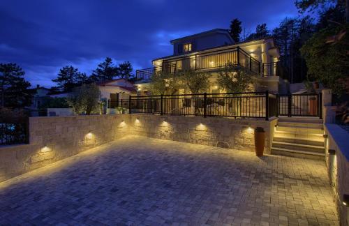 a house with lights in front of it at night at Villa Sea Queen in Šilo