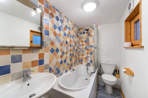 uma casa de banho com um lavatório, uma banheira e um WC. em Résidence Dandrina - Chalets pour 8 Personnes 274 em le Praz