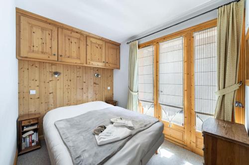 um quarto com uma cama e uma grande janela em Résidence Dandrina - Chalets pour 8 Personnes 274 em le Praz