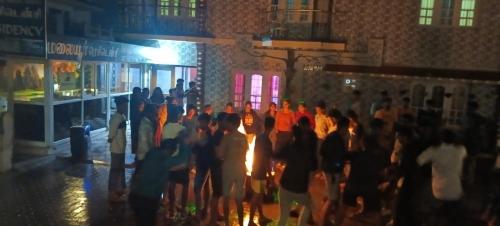 a crowd of people standing on a street at night at MR staye in Ooty