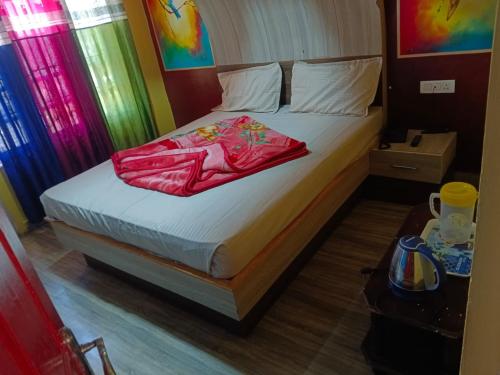 - une chambre avec un lit et une couverture rouge dans l'établissement MR staye, à Ooty